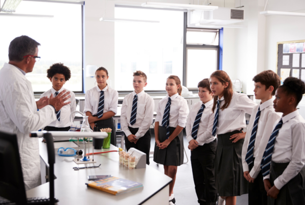A group of secondary school students listen to a teacher